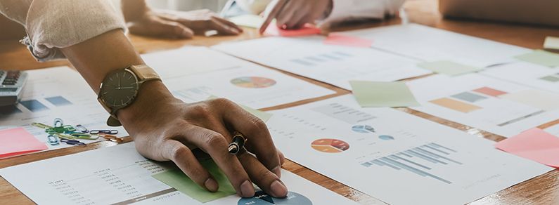 Close-up of colleagues examining charts and graphs